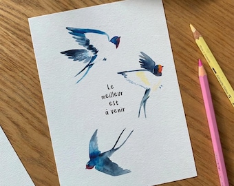 Peut inclure: Une peinture à l'aquarelle sur papier blanc représentant trois hirondelles bleues et blanches en plein vol. Le texte "Le meilleur est à venir" est écrit à l'encre noire au centre. Les oiseaux présentent des touches orange sur la tête.