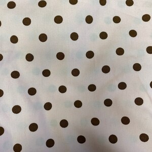 May include: White fabric with a repeating pattern of brown polka dots.