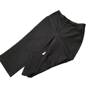 Pode incluir: Um par de cal&ccedil;as de fato cinza escuro. As cal&ccedil;as t&ecirc;m corte reto, fecho frontal e bolsos. O tecido parece ser um material tecido. As cal&ccedil;as est&atilde;o dobradas e colocadas sobre um fundo branco.