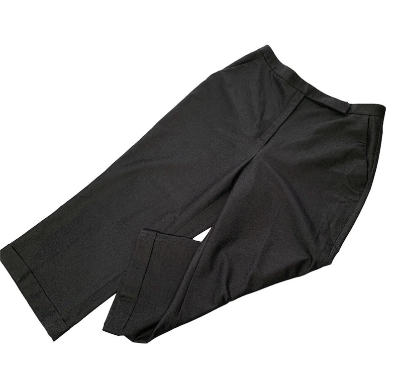 Pode incluir: Um par de cal&ccedil;as de fato cinza escuro. As cal&ccedil;as t&ecirc;m corte reto, fecho frontal e bolsos. O tecido parece ser um material tecido. As cal&ccedil;as est&atilde;o dobradas e colocadas sobre um fundo branco.
