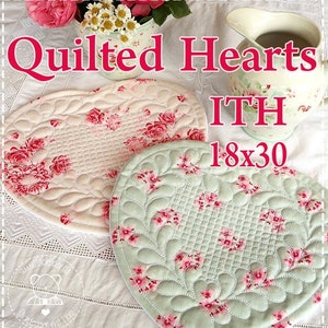 Könnte beinhalten: Herzförmige, gesteppte Tischsets mit einem rosa-roten Blumenmuster. Die Tischsets sind cremefarben und mintgrün, mit dem Text "Quilted Hearts" und "18x30" (ca. 46cm x 76cm) im Bild. Die Tischsets sind mit einem Blumendesign verziert.