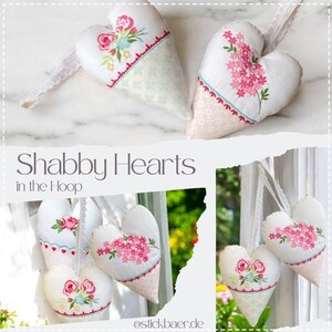 May include: Two stuffed fabric hearts with white lace ribbons, featuring embroidered pink floral designs and light blue or pink patterned fabric sections. The text "Shabby Hearts in the Hoop" and "stickbaer.de" is visible on the image.