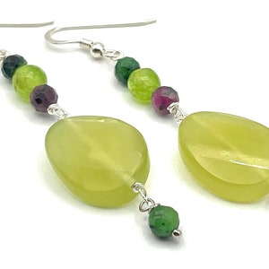 Può includere: Un paio di orecchini d'argento con perline di pietre preziose verdi, viola e verde chiaro e una grande pietra ovale verde chiaro.
