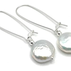May include: A pair of silver dangle earrings with large, white, round, irregular shaped pearls.
