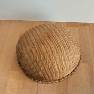 Pu&ograve; includere: Un cesto rotondo intrecciato di colore marrone chiaro naturale. Il cesto presenta un motivo a trama fitta e una forma arrotondata. Il bordo &egrave; rinforzato con una trama pi&ugrave; spessa. Poggia su una superficie di legno marrone chiaro. Il cesto misura circa 30 cm di diametro.