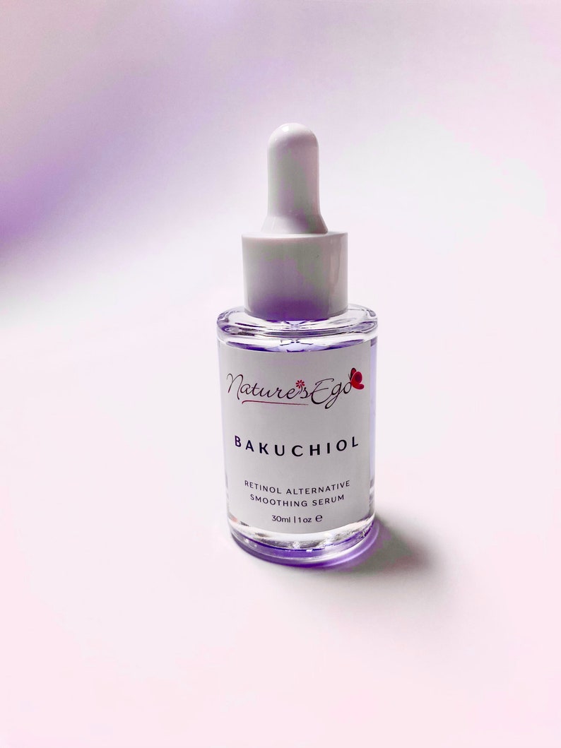 May include: A clear glass bottle with a white dropper top and a white label. The label says "Nature's Ego Bakuchiol Retinol Alternative Smoothing Serum 30ml | 1 fl oz e".