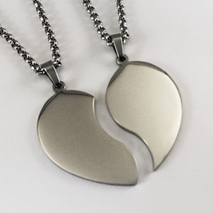 Puede incluir: Dos collares de plata con colgantes de coraz&oacute;n a juego que encajan. Los colgantes son lisos y brillantes.
