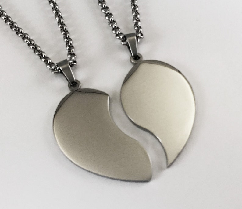 Puede incluir: Dos collares de plata con colgantes de coraz&oacute;n a juego que encajan. Los colgantes son lisos y brillantes.