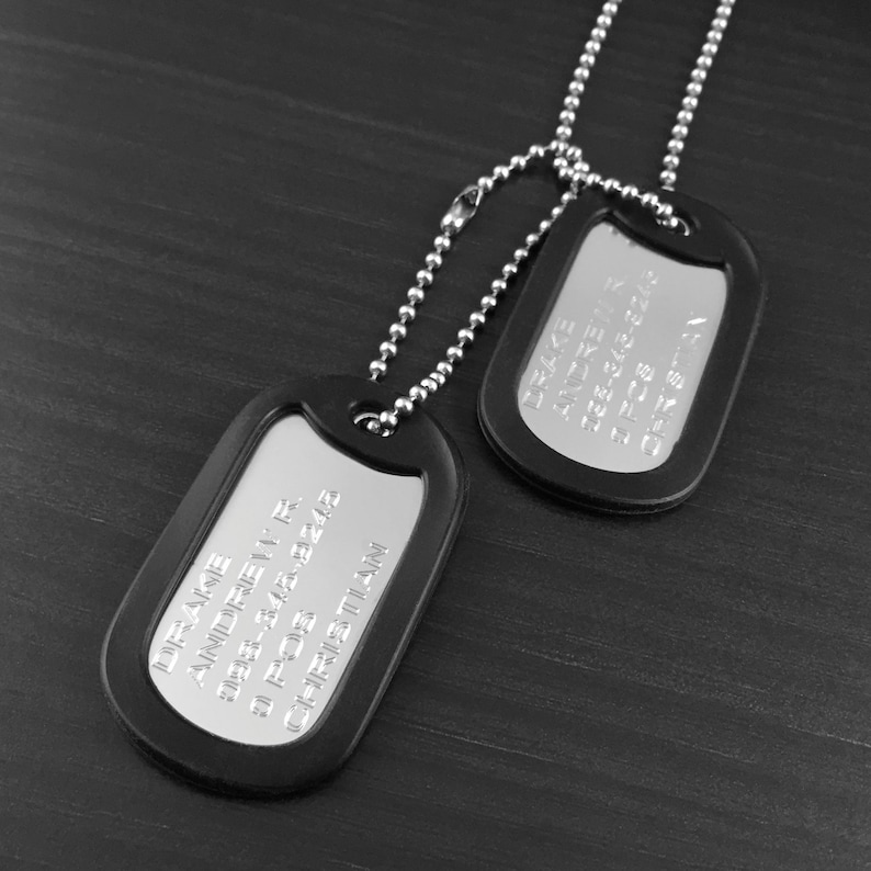 May include: Two black metal dog tags on a silver chain. The top tag reads "MIKE ANDREWS 988-348-8243 51 POS CHRIS TILLMAN". The bottom tag reads "MIKE ANDREWS 988-348-8243 51 POS CHRIS TILLMAN".