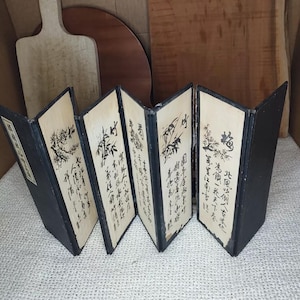 May include: A six-panel folding screen with black frames and a cream-colored background. Each panel features black calligraphy and a stylized bamboo design. The text on the panels reads: "大國魂神社", "御神號", "天照大神", "豊受大神", "春日大社", "御祭神".