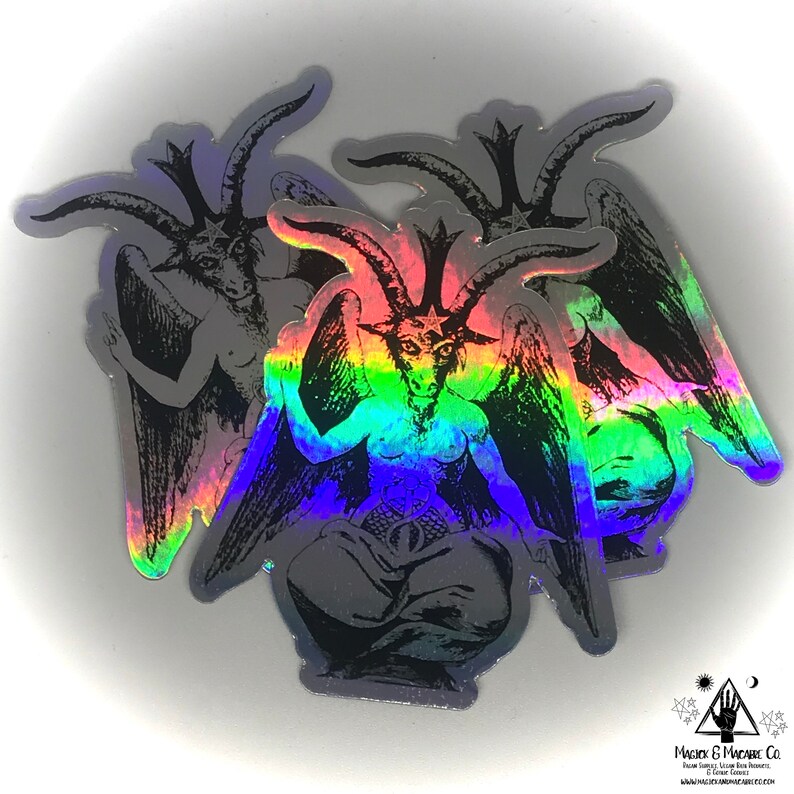 May include: Three iridescent holographic stickers featuring a black and white image of a goat-headed figure with wings and a star on its forehead. The figure is sitting with its legs crossed and its hands raised in a gesture of blessing. The stickers are rainbow iridescent.