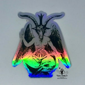 May include: A holographic sticker featuring a black and white illustration of a winged demon with horns and a pentagram on its forehead. The demon is sitting in a meditative pose with its hands resting on its knees. The sticker has a rainbow iridescent background.