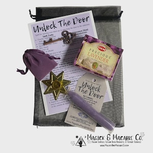 May include: A collection of spiritual items, including a purple candle, incense, a key charm, and a star-shaped candle holder, presented in a black drawstring bag. The kit includes a card with the text "Unlock The Door".