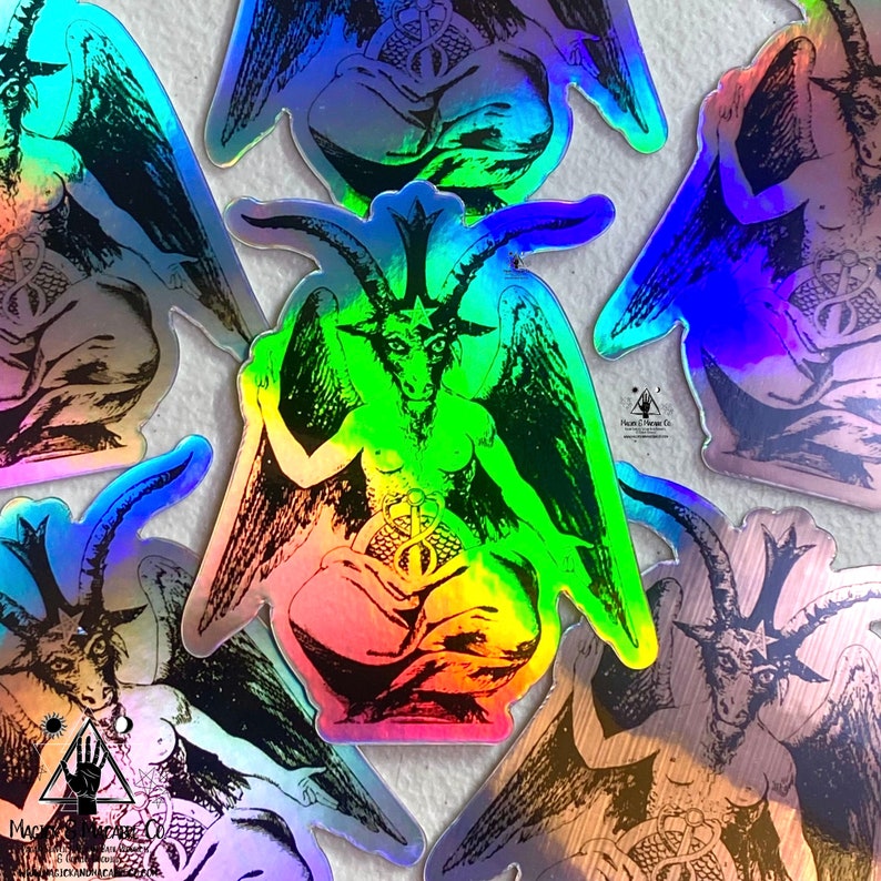 May include: A set of five iridescent holographic stickers featuring a black and white illustration of a winged, horned figure with a pentagram on its forehead. The figure is sitting with its legs crossed and holding a snake in its hands. The stickers are all different sizes and shapes, and they are all very colorful.