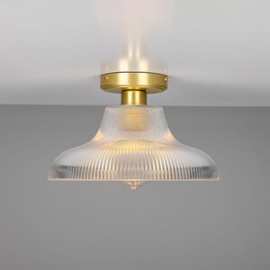 May include: A gold ceiling light fixture with a clear, ribbed glass shade.