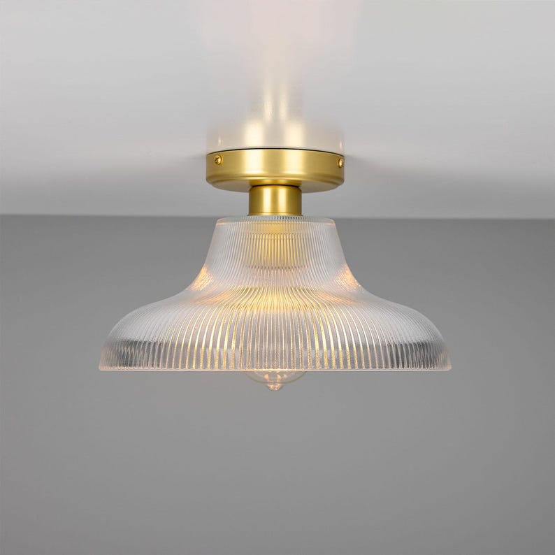 May include: A gold ceiling light fixture with a clear, ribbed glass shade.