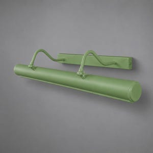 May include: A sage green picture light fixture featuring a long, cylindrical lamp head attached to a rectangular wall-mounting plate by two curved, adjustable metal arms. The entire unit has a smooth, matte finish and a minimalist, functional design.