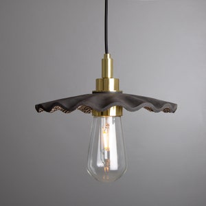 May include: A black and gold pendant light with a scalloped, textured shade and a clear glass bulb.