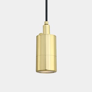 May include: A cylindrical pendant light fixture with a brushed brass finish. The light hangs from a black cord and features a small, round button on the side. The bottom of the fixture has a recessed light source.