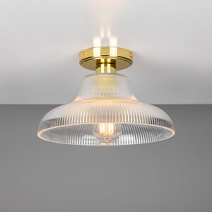 May include: A gold ceiling light fixture with a clear, ribbed glass shade.