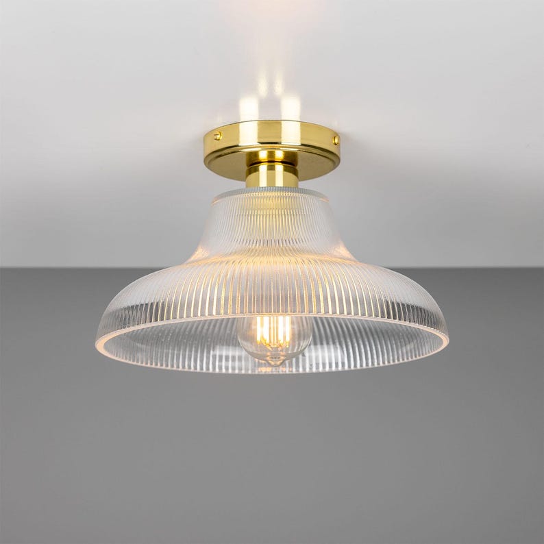 May include: A gold ceiling light fixture with a clear, ribbed glass shade.