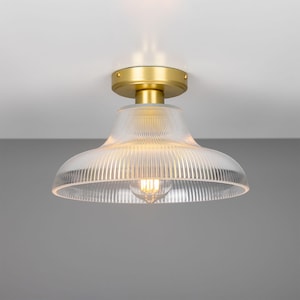 May include: A gold ceiling light fixture with a clear, ribbed glass shade.