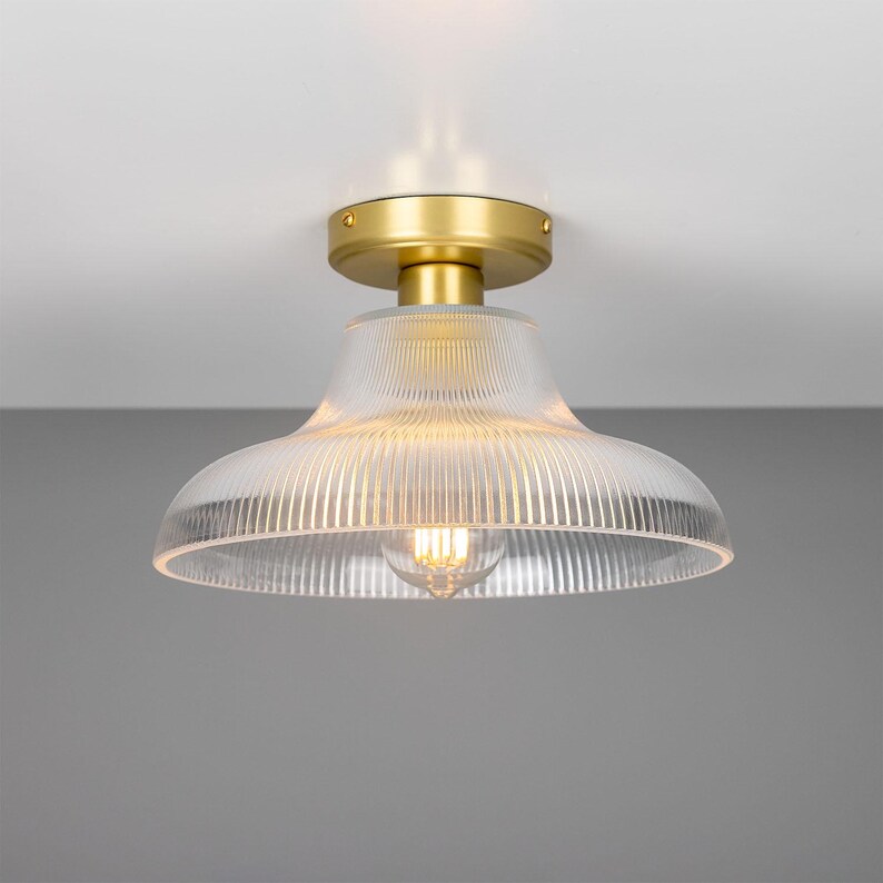 May include: A gold ceiling light fixture with a clear, ribbed glass shade.