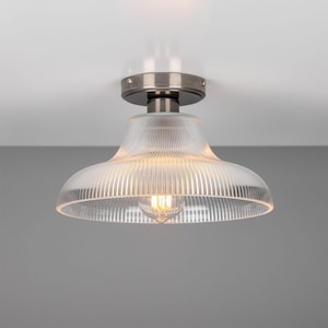 May include: A silver ceiling light fixture with a clear, ribbed glass shade.