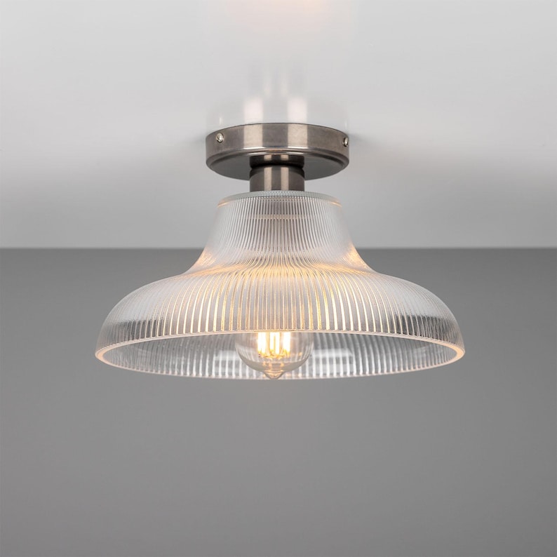 May include: A silver ceiling light fixture with a clear, ribbed glass shade.