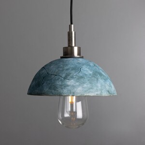 May include: A blue, textured, dome-shaped pendant light with a silver metal fixture and a clear glass light bulb.