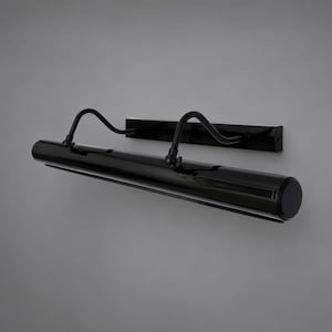 May include: A sleek black picture light featuring a long cylindrical lamp head attached to a rectangular wall-mounting plate by two curved, adjustable metal arms. The entire fixture has a smooth, glossy finish and a minimalist, linear design.