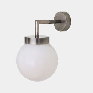 Pode incluir: Uma arandela de parede prateada com um globo de vidro branco fosco. A arandela tem um design simples e moderno.