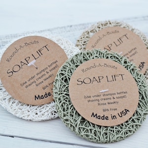 May include: Three white, green, and beige soap lift pads with brown paper labels that read "Round-A-Bouts Soap Lift" and instructions for use. The labels also say "Made in USA" and "BPA Free".