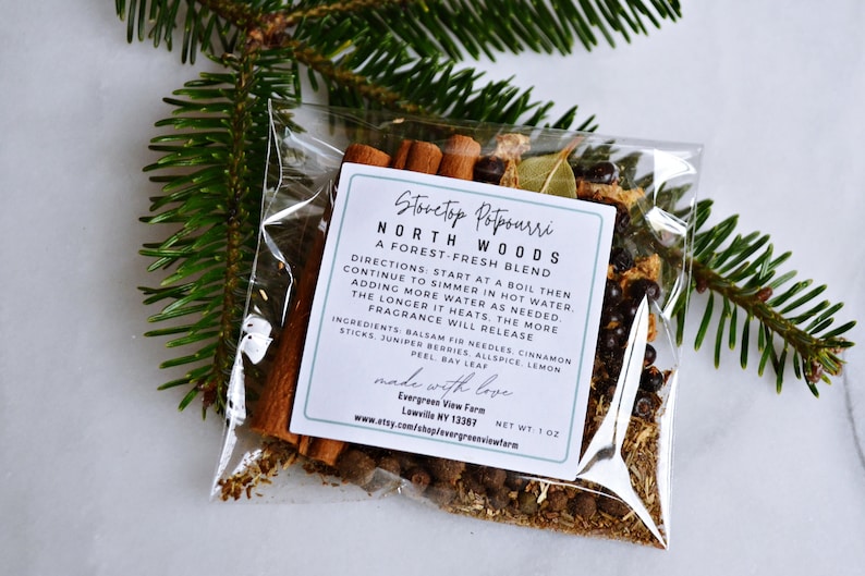 Pu&ograve; includere: Un sacchetto di plastica trasparente riempito con una miscela di erbe e spezie essiccate per pot-pourri da stufa. L'etichetta recita "Stovetop Potpourri North Woods A Forest-Fresh Blend" e include le istruzioni per l'uso. Gli ingredienti includono aghi di abete balsamico, bastoncini di cannella, bacche di ginepro, pimento, scorza di limone e foglia di alloro. Il sacchetto &egrave; da 1 oz ed &egrave; prodotto da Evergreen View Farm a Lowville, NY.
