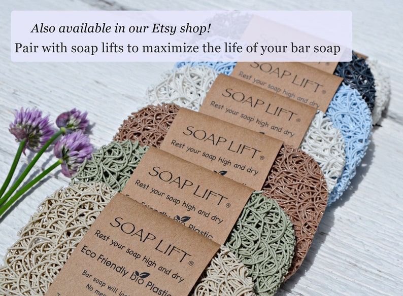 May include: A close-up of six soap lifts made of natural materials. The soap lifts are in various colors, including beige, brown, green, and blue. The soap lifts are arranged in a row, with the text "SOAP LIFT" and "Rest your soap high and dry" printed on each one. The text "Eco Friendly bio Plastic" is printed on the bottom soap lift.