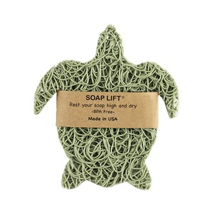 May include: Green turtle-shaped soap dish made of woven plastic. The dish has a label that reads "SOAP LIFT&reg; Rest your soap high and dry -BPA Free- Made in USA".