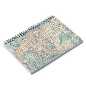 May include: A vintage style spiral notebook with a map of North America on the cover. The map is in shades of blue, green, and brown, with the text "United States" and "Dominion of Canada" visible.