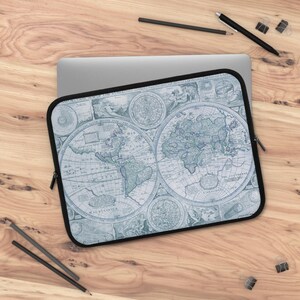 May include: A laptop sleeve featuring a vintage world map design in shades of blue and white. The sleeve has a black border and a zipper closure. The map depicts continents and oceans with intricate details, creating a classic aesthetic.