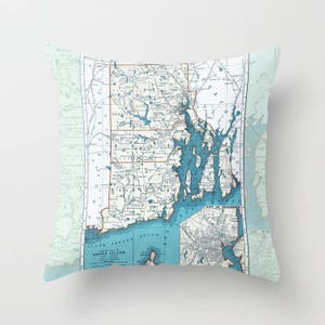 May include: A vintage map of Rhode Island with blue and brown lines and text. The map is on a light blue background with a white border. The map shows the state's coastline, major cities, and towns. The text on the map includes "Rhode Island" and "City of Providence".