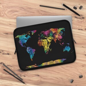 Könnte beinhalten: Schwarze Laptoptasche mit einem farbenfrohen, geometrischen Weltkarten-Design. Die Karte besteht aus verschiedenen farbigen Dreiecken, darunter Blau, Grün, Gelb und Rosa. Die Tasche hat einen schwarzen Reißverschluss und liegt auf einer Holzoberfläche.