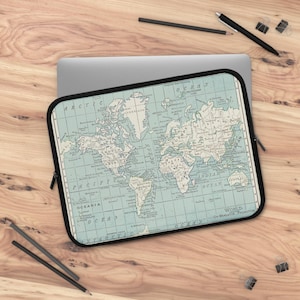Könnte beinhalten: Eine Laptop-Hülle mit einem Vintage-Weltkarten-Design in Blau- und Beigetönen. Die Hülle hat einen schwarzen Rand und einen Reißverschluss. Die Karte enthält geografische Details und Ozeannamen.