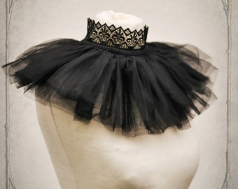 May include: A black lace and tulle collar with a ruffled design. The collar is on a white mannequin.