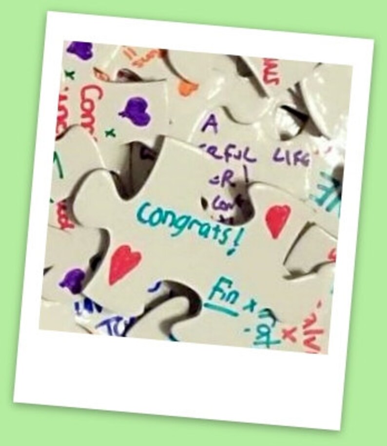 Puede incluir: Un rompecabezas blanco con las palabras "A Careful Life" y "Congrats!" escritas en &eacute;l. Las piezas del rompecabezas est&aacute;n decoradas con corazones y otros dibujos.