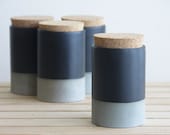 Small ceramic jar with cork lid in gray with black matte glaze.