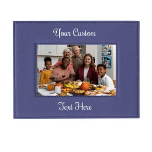 May include: A purple leather photo frame with a stitched border. The frame has a window for a photo and the text "Your Custom" and "Text Here" is printed in white on the frame.