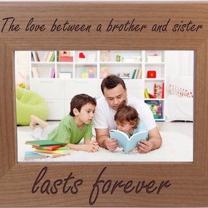 May include: A wooden picture frame with a photo of a father reading a book to his two children. The frame has the text "The love between a brother and sister lasts forever" engraved on it.