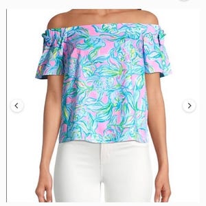 Puede incluir: Top con hombros descubiertos con un vibrante estampado floral en rosa, azul y verde. El top tiene mangas cortas y se combina con pantalones blancos. Es una prenda de vestir para mujer.