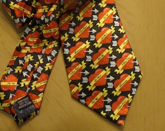 May include: A black silk tie with a repeating pattern of red hearts with arrows and the text "I Love You" on a yellow banner.