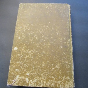 Pu&ograve; includere: Un libro consumato di colore beige con una copertina testurizzata. Il libro &egrave; chiuso e il dorso &egrave; visibile.