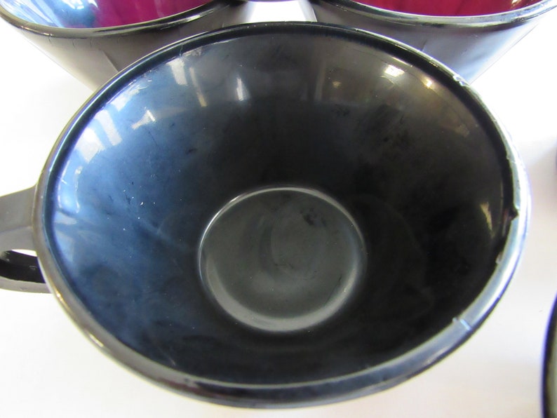 May include: A black ceramic coffee mug with a smooth, glossy finish. The mug is empty and the inside is visible.